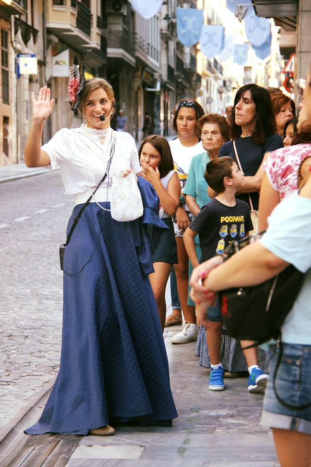 mujer realizando una visita guiada sobre el modernismo, vestida como en la época